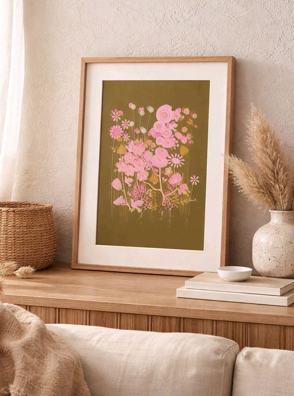 Niitty on kaunis ja harmoninen sisustusjuliste, jossa on tummanvihreällä taustalla mätäs erilaisia piirrettyjä niittykukkia pinkin, roosan ja sinapinkeltaisen sävyissä.